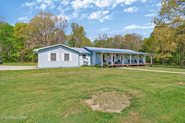 a view of a house with a yard table and chairs