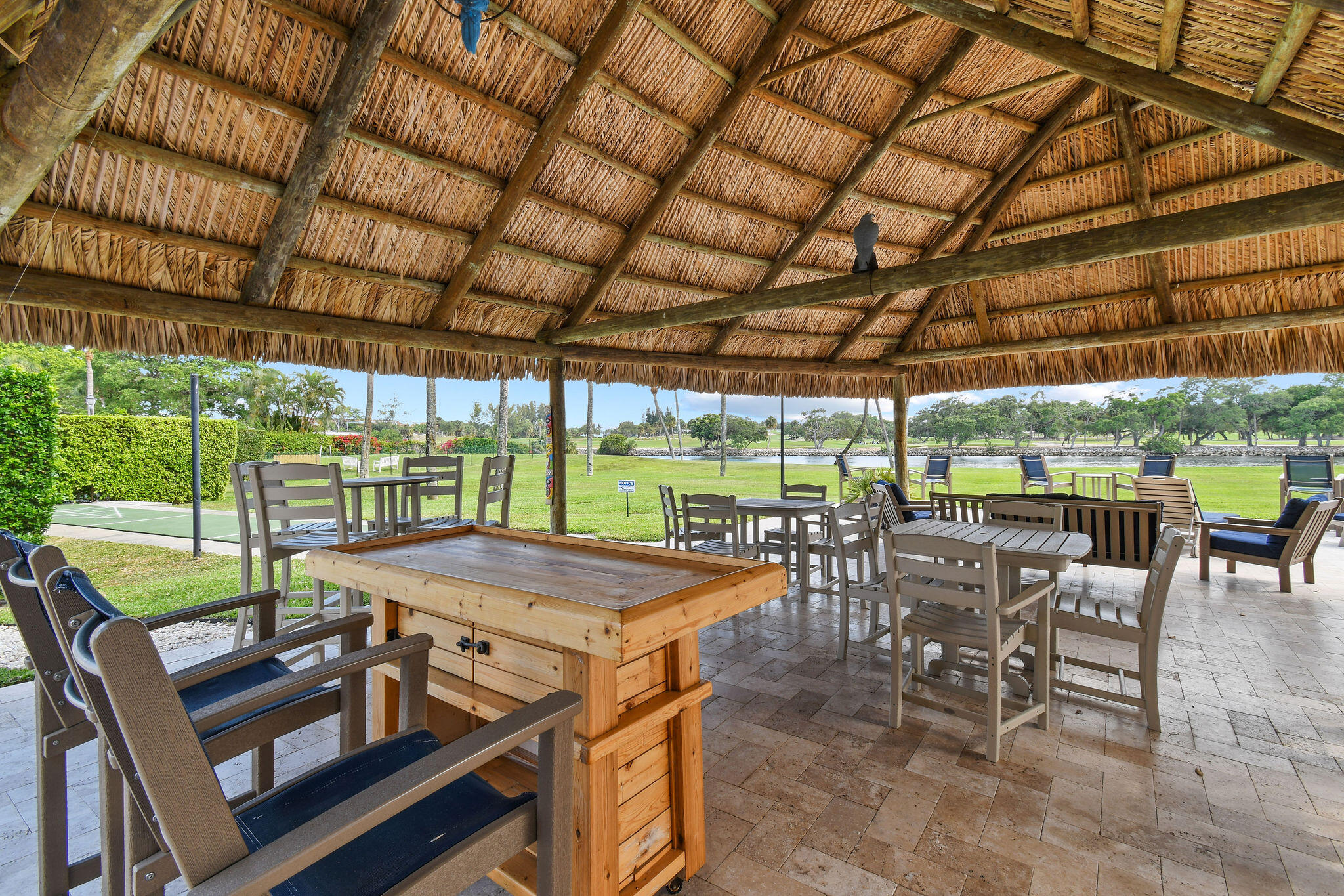 336 Golfview Road, Unit 408 North Palm Beach, FL 33408 - Photo 26 of 39 a view of a patio with table and chairs under an umbrella next to a yard