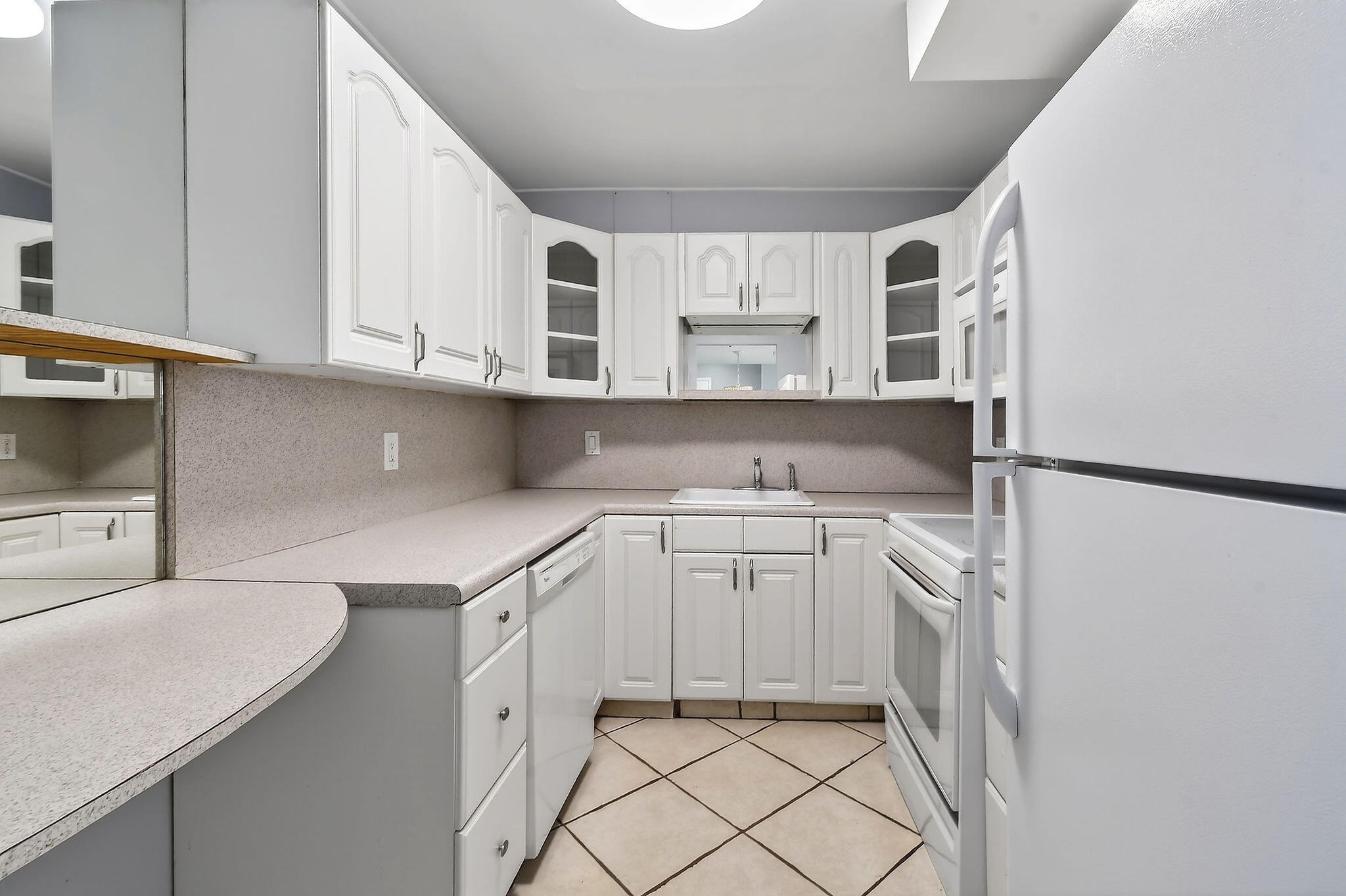 336 Golfview Road, Unit 408 North Palm Beach, FL 33408 - Photo 6 of 39 a kitchen with white cabinets and appliances