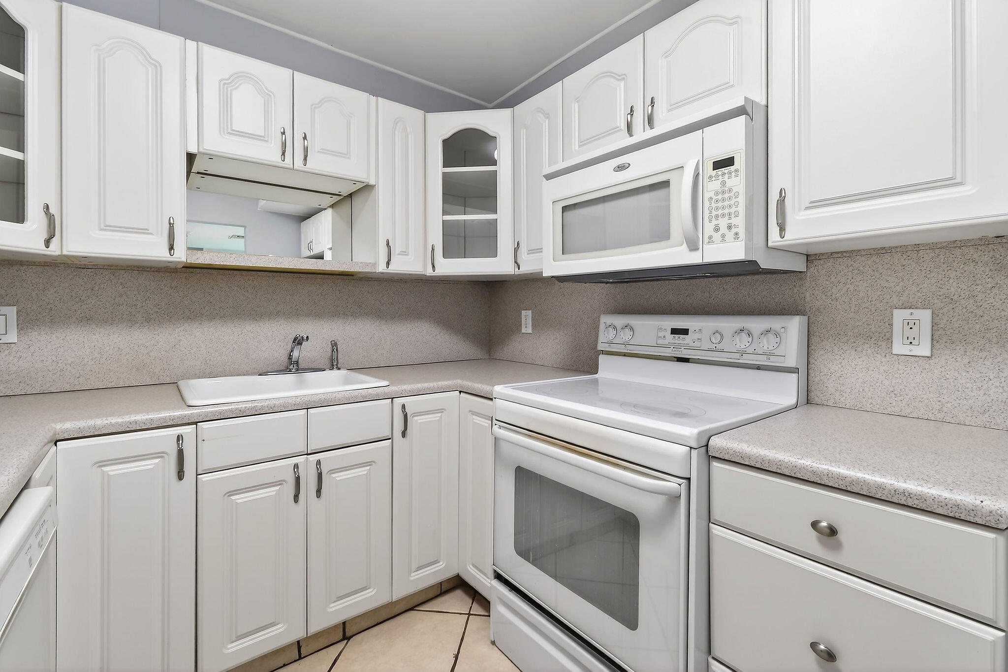 336 Golfview Road, Unit 408 North Palm Beach, FL 33408 - Photo 8 of 39 a kitchen with white cabinets and white appliances