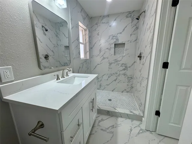 a bathroom with a sink a mirror and a shower