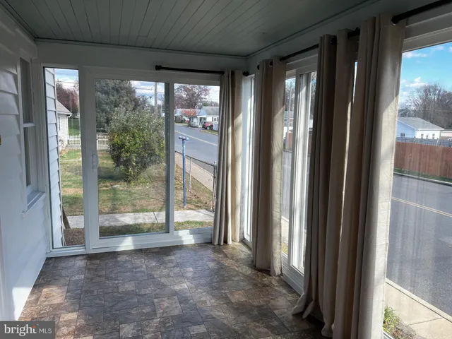 a view of a room with large windows and front door