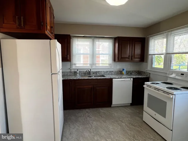 a view of kitchen filled with furniture and a refrigerator
