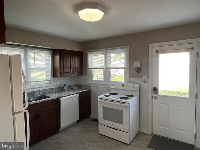a view of open kitchen with a sink stove and refrigerator