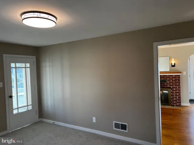 an empty room with wooden floor and mirror