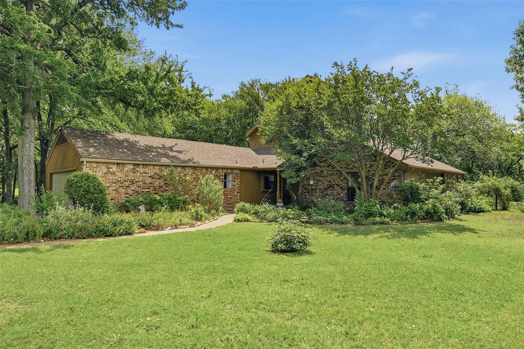 522 High Country Road Sherman, TX 75092 - Photo 2 of 38 a backyard of a house with table and chairs under an umbrella