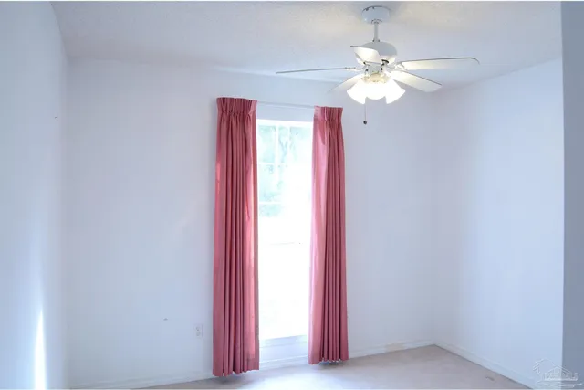 a view of a bedroom with a chandelier fan and a window