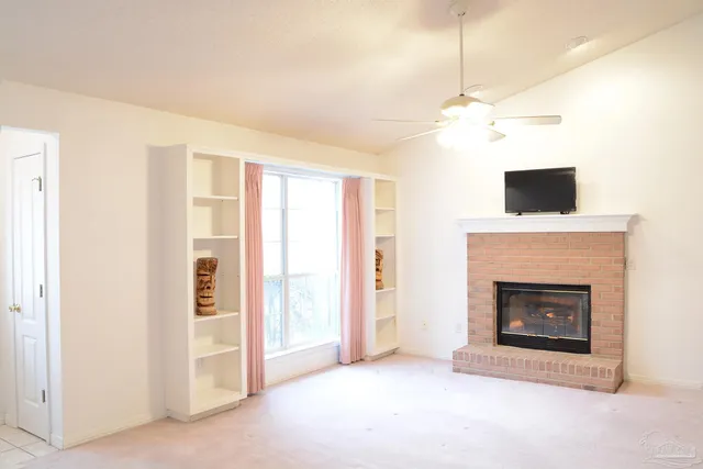 a view of a livingroom with a fireplace and a ceiling fan