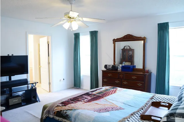 a bedroom with a bed and a flat tv screen on dresser