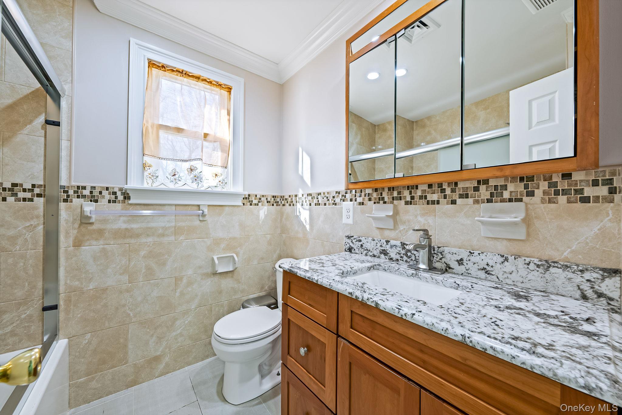 20 Howe Road Coram, NY 11727 - Photo 17 of 25 a bathroom with a granite countertop sink a toilet and a mirror