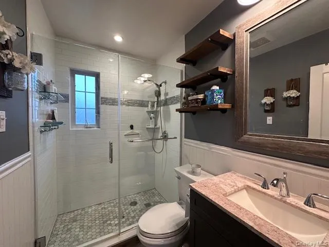 a bathroom with a sink a toilet and shower