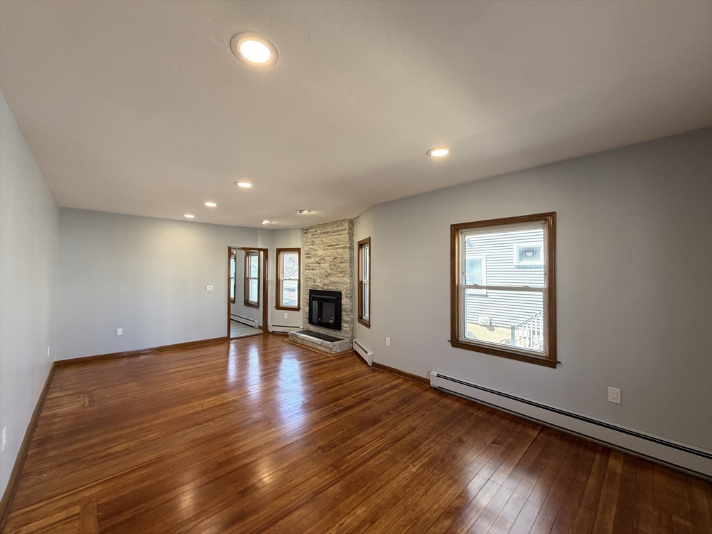 117 Merrymount Road, Unit 1 Quincy, MA 02169 - Photo 12 of 12 a view of an empty room with wooden floor and a window
