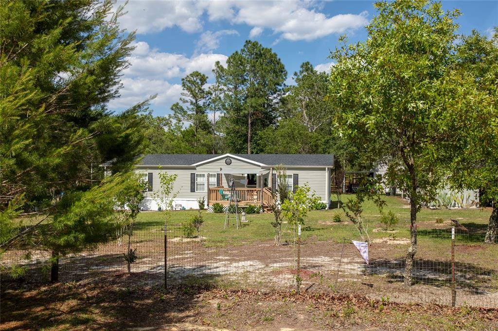 a view of a yard in front of a house with large trees