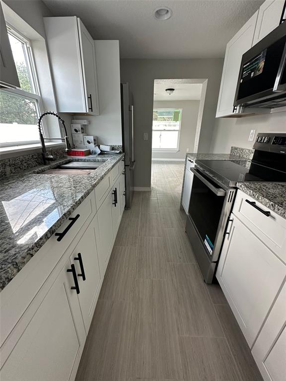 2015 Laurel Street Bartow, FL 33830 - Photo 7 of 18 a kitchen with stainless steel appliances granite countertop a sink a stove and a wooden floors