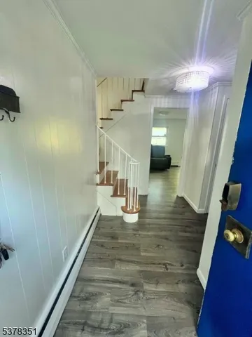 a view of entryway and hall with wooden floor