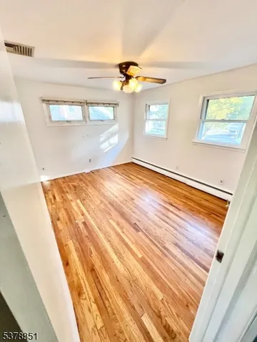a view of empty room with wooden floor