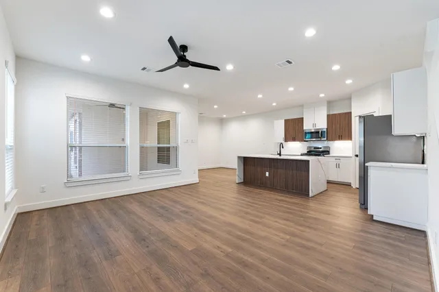 a view of kitchen with kitchen island stainless steel appliances sink and cabinets