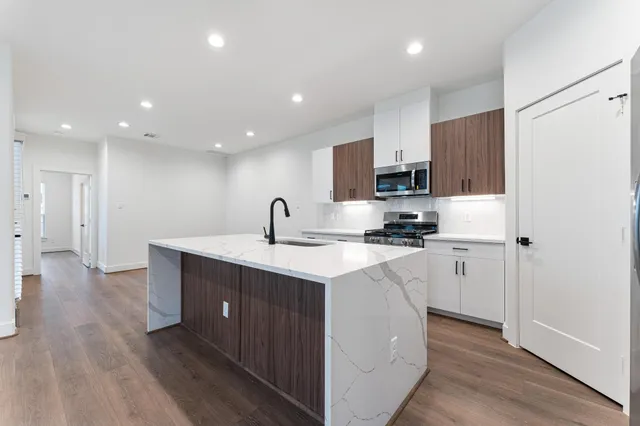 a kitchen with a sink stainless steel appliances and cabinets