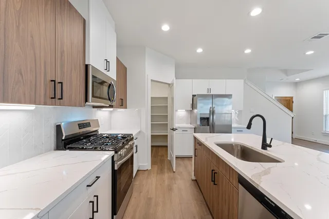 a kitchen with kitchen island a sink stainless steel appliances and cabinets
