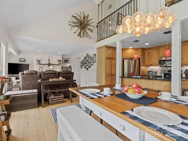 a kitchen with stainless steel appliances kitchen island granite countertop a stove and a flat screen tv