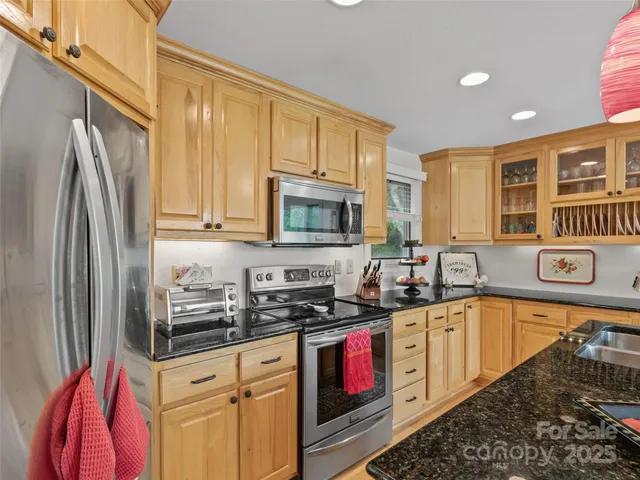 a kitchen with stainless steel appliances granite countertop a stove a sink and a microwave