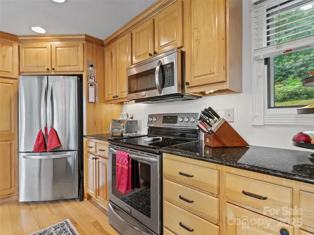 a kitchen with stainless steel appliances granite countertop a stove a sink and a refrigerator