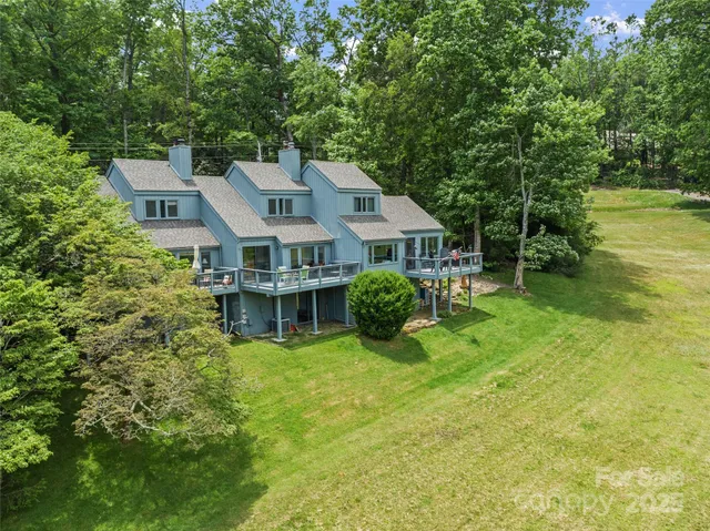 a aerial view of a house with swimming pool next to a big yard