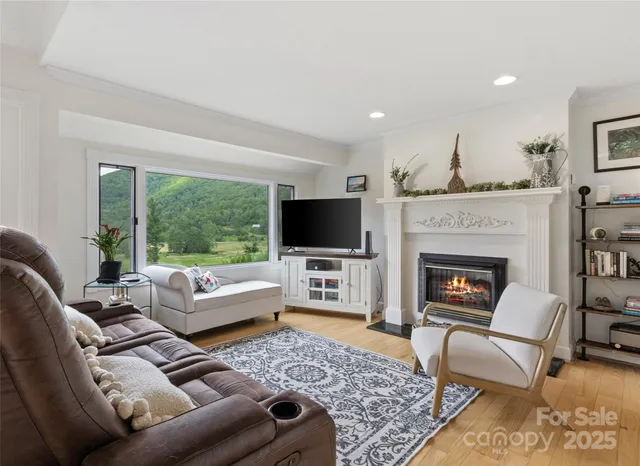 a living room with furniture a flat screen tv and a fireplace