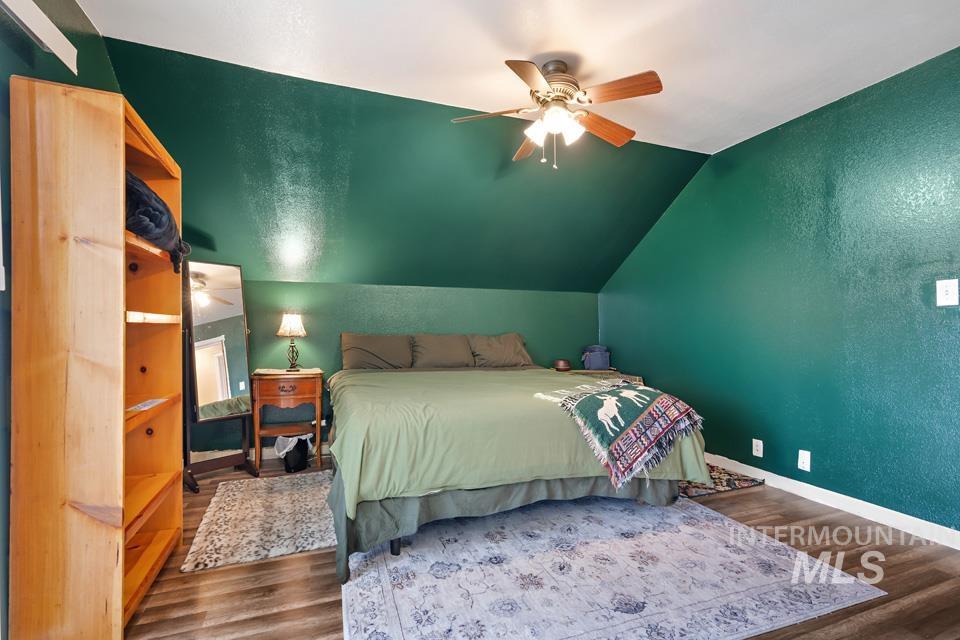 1230 East Main Street Weiser, ID 83672 - Photo 15 of 25 Bedroom featuring a textured wall, wood finished floors, vaulted ceiling, and ceiling fan