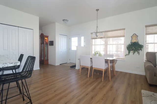 a dining room with furniture a chandelier and wooden floor