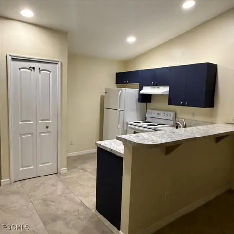 a kitchen with kitchen island stainless steel appliances a sink and a refrigerator