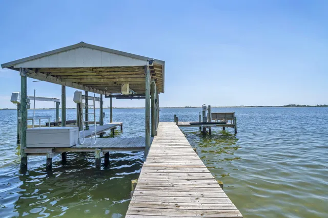 a view of a balcony with chairs and wooden floor