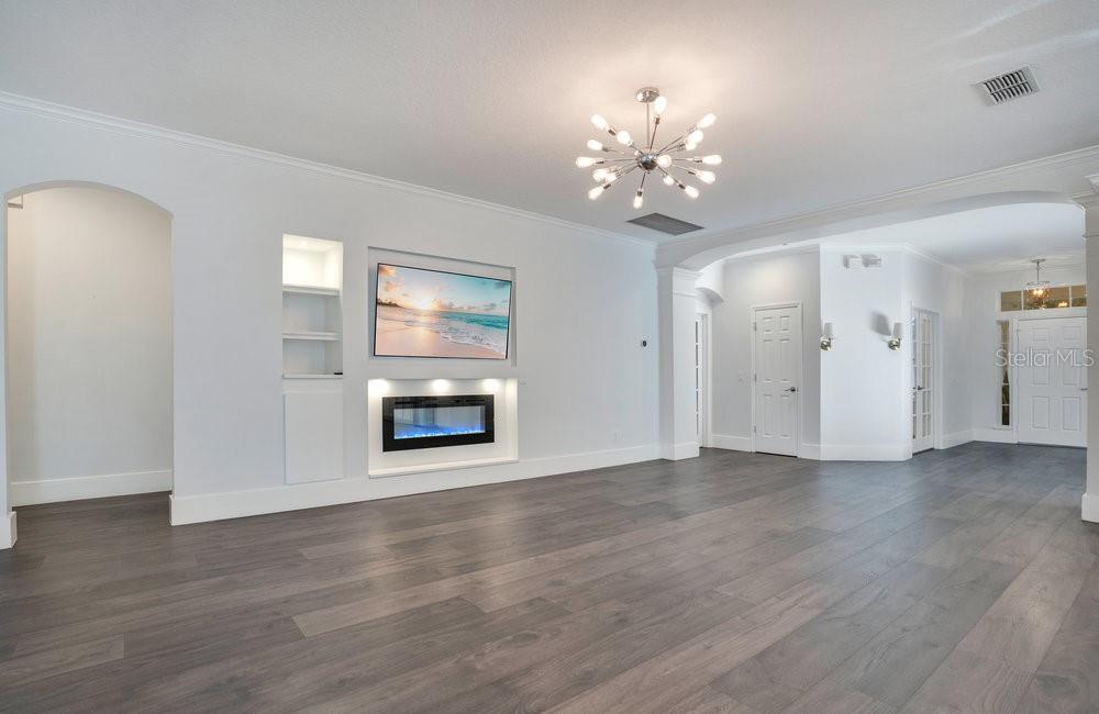 8399 Bowden Way Windermere, FL 34786 - Photo 14 of 59 a view of an empty room with a fireplace and wooden floor