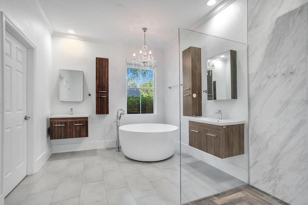 8399 Bowden Way Windermere, FL 34786 - Photo 22 of 59 a spacious bathroom with a double vanity sink a large mirror and a bathtub