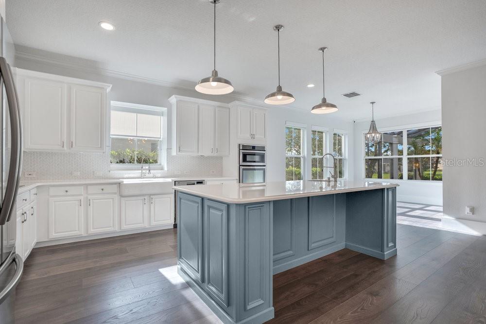 8399 Bowden Way Windermere, FL 34786 - Photo 6 of 59 a kitchen with stainless steel appliances granite countertop wooden floors sink and cabinets
