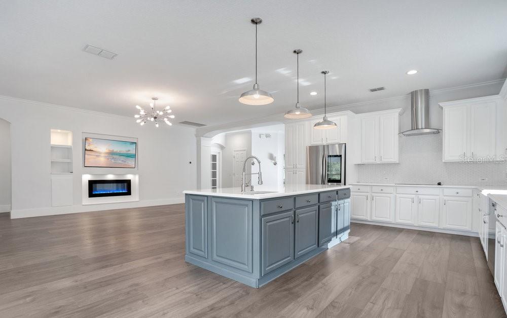 8399 Bowden Way Windermere, FL 34786 - Photo 9 of 59 a large kitchen with kitchen island a stove a sink a center island and wooden floor