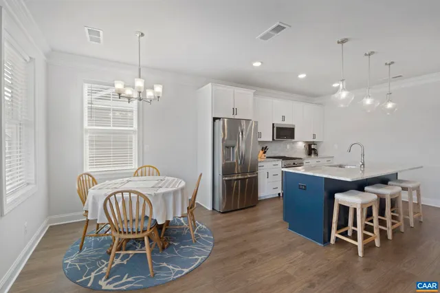 a view of a dining room with furniture a chandelier and wooden floor