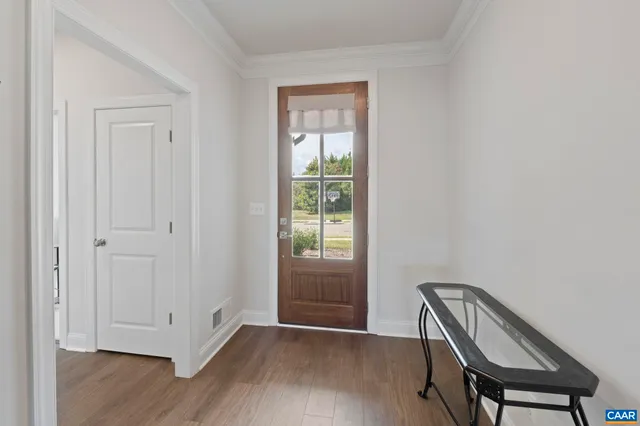 a view of a hallway with wooden floor and closet