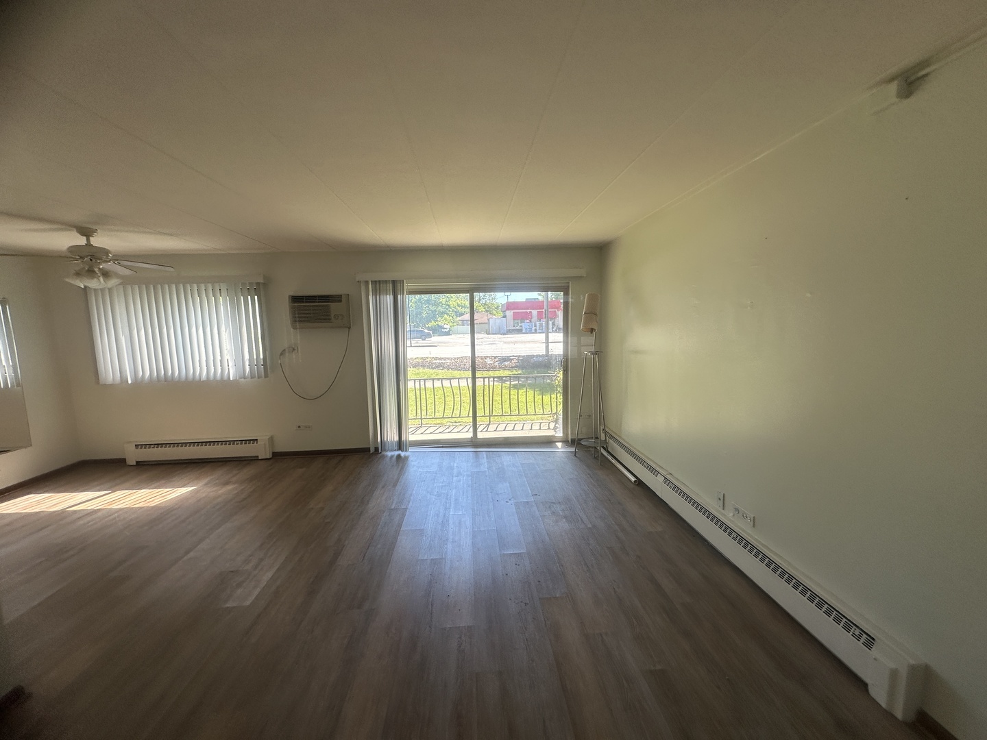 18550 Torrence Avenue, Unit 4 Lansing, IL 60438 - Photo 2 of 14 an empty room with wooden floor and windows