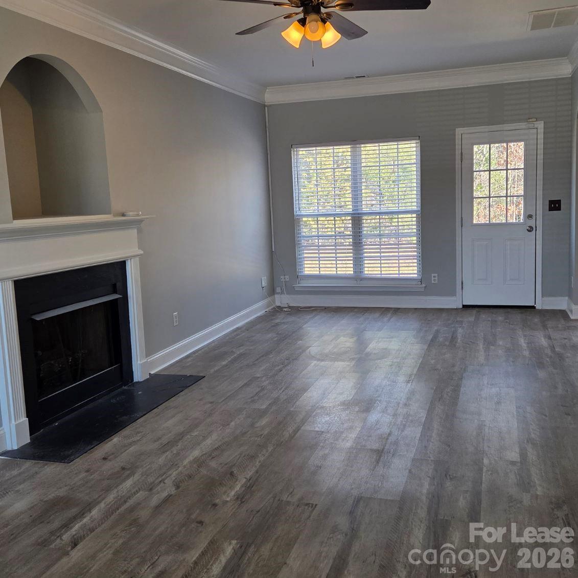 5840 Timbertop Lane Charlotte, NC 28215 - Photo 2 of 34 an empty room with wooden floor fireplace and windows