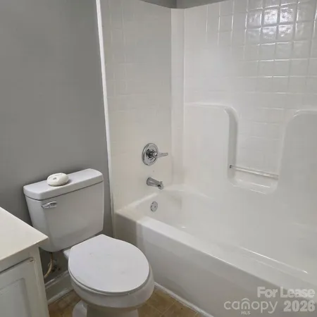a white toilet sitting next to a bath tub