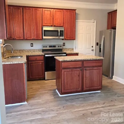 a kitchen with stainless steel appliances granite countertop a stove a sink dishwasher a refrigerator and a microwave oven