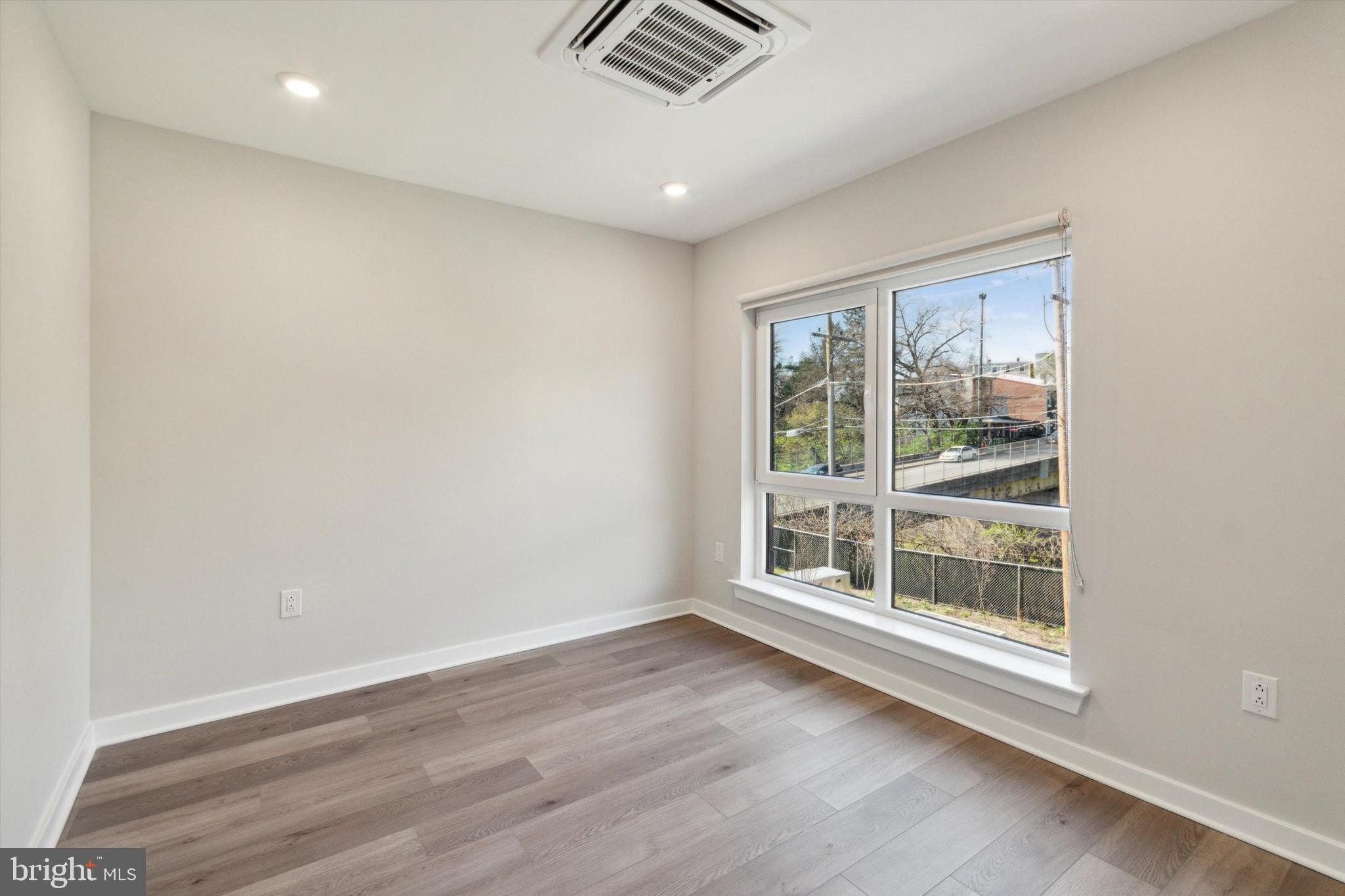 3449 Scotts Lane, Unit B309 Philadelphia, PA 19129 - Photo 3 of 6 an empty room with wooden floor and windows
