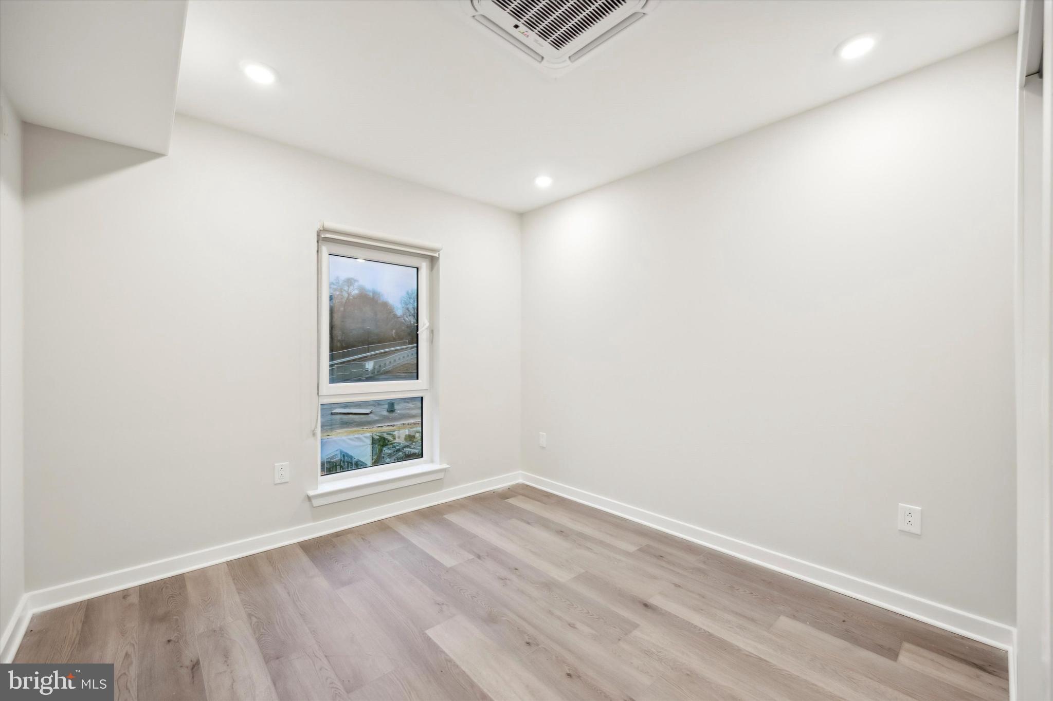 3449 Scotts Lane, Unit B309 Philadelphia, PA 19129 - Photo 5 of 6 an empty room with wooden floor and windows