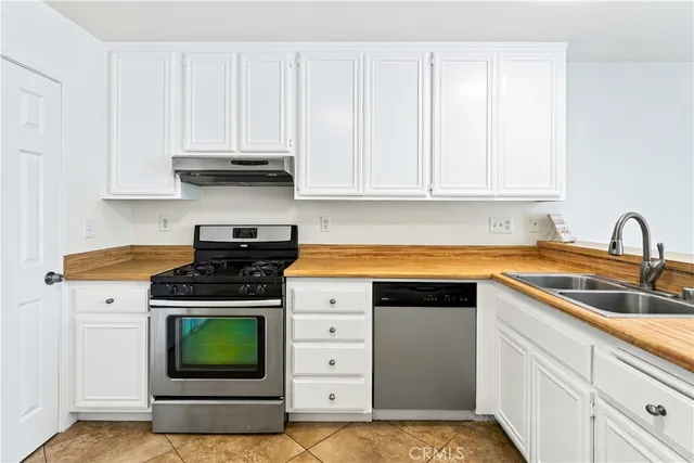 a kitchen with a stove and white cabinets