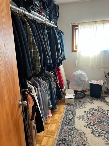 a view of walk in closet with clothes and shoes