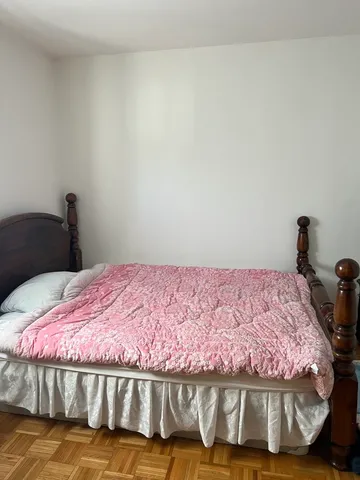 a bedroom with a bed and a wooden floor