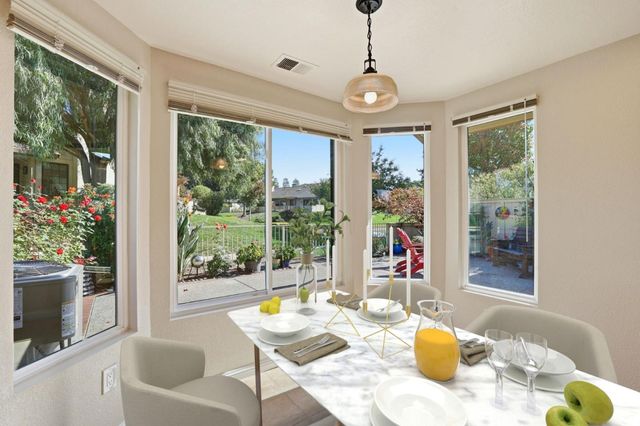 a view of a dining room with furniture a chandelier and windows