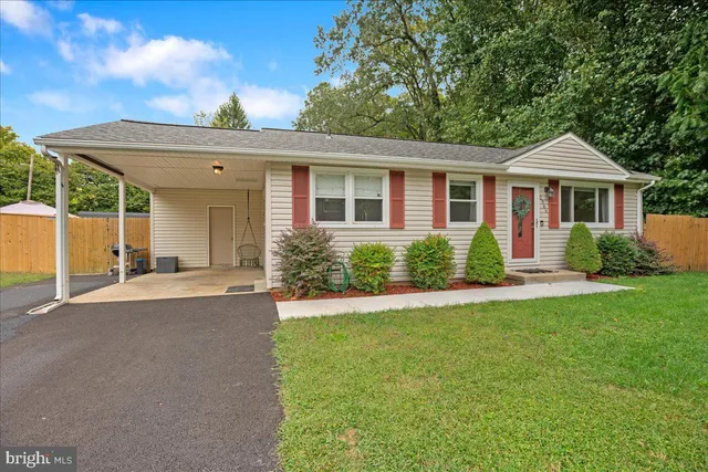 a front view of a house with a yard and potted plants