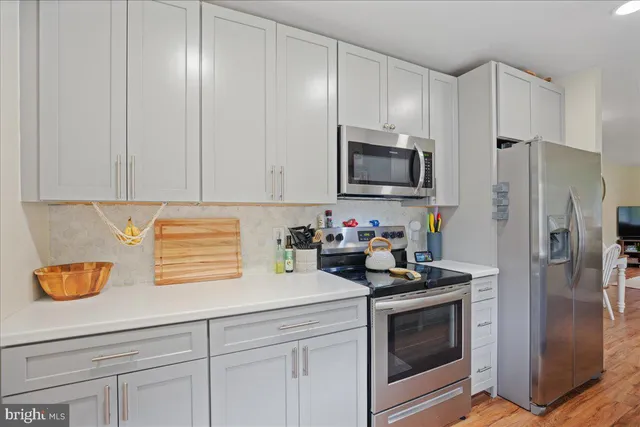 a kitchen with stainless steel appliances granite countertop a refrigerator sink and stove